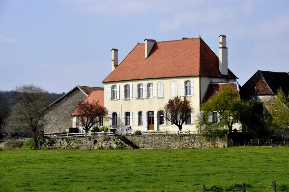 Das Gutshaus mit rotem Dach, heller Fassade und grüner Wiese