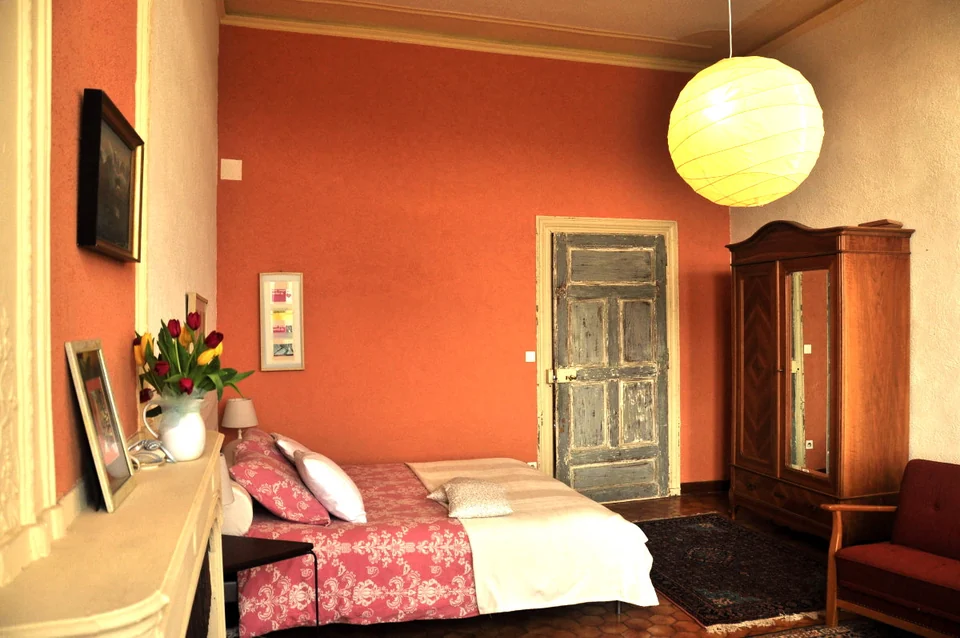 Gästezimmer mit roten Wänden und Holzmöbeln